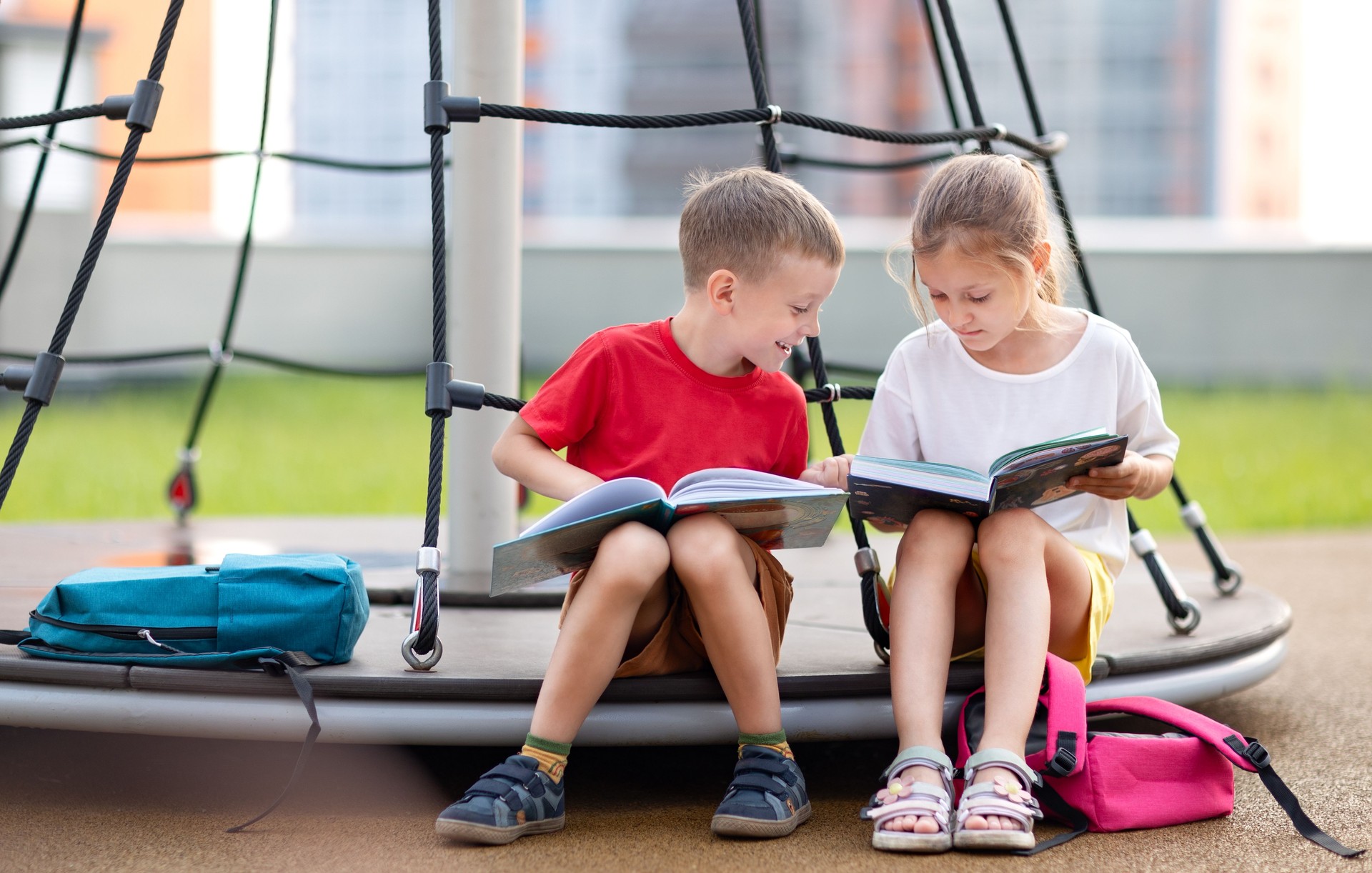 Kids are reading books on the playground after school
